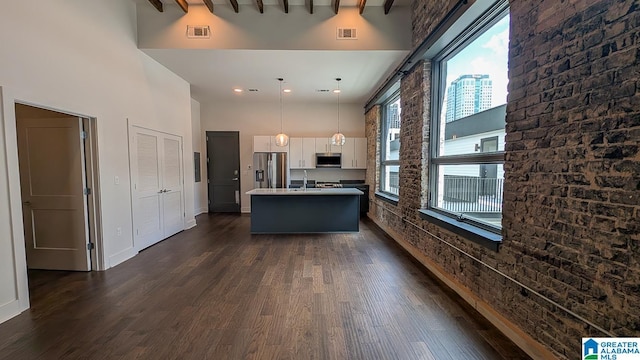 1801 2nd Ave N Unit 406, Birmingham, AL 35203 - kitchen featuring a towering ceiling, stainless steel appliances, dark wood-type flooring, a center island with sink, and hanging light fixtures