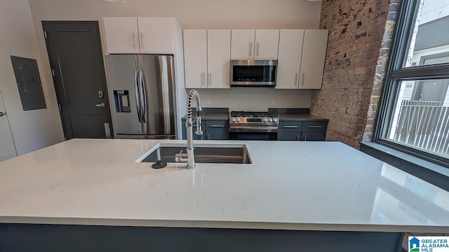 1801 2nd Ave N Unit 406, Birmingham, AL 35203 - kitchen featuring appliances with stainless steel finishes, electric panel, light stone countertops, and white cabinets