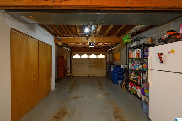 2418 Richelieu Ln, Hoover, AL 35216 - garage featuring freestanding refrigerator, a garage door opener, and concrete block wall
