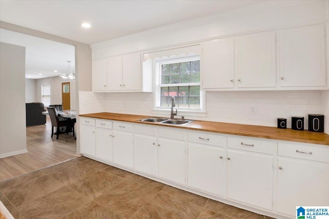 1818 Hillcrest Rd NE, Center Point, AL 35215 - kitchen with butcher block countertops, plenty of natural light, decorative backsplash, white cabinetry, and recessed lighting