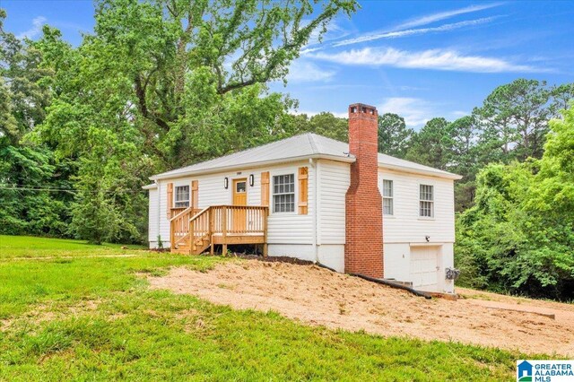 1818 Hillcrest Rd NE, Center Point, AL 35215 - rear view of property with a chimney, an attached garage, and a yard