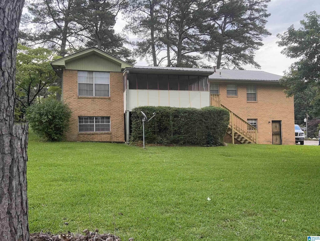 812 2nd Ave, Pleasant Grove, AL 35127 - rear view of house featuring brick siding, a sunroom, stairway, and a lawn