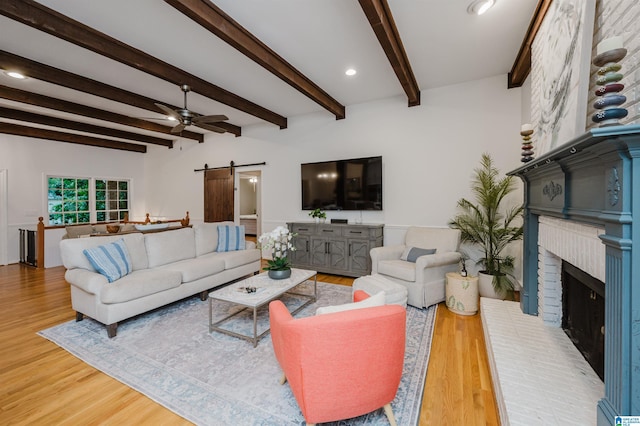 3204 Woodford Way, Birmingham, AL 35242 - living room with a barn door, wood finished floors, a ceiling fan, beamed ceiling, and a brick fireplace