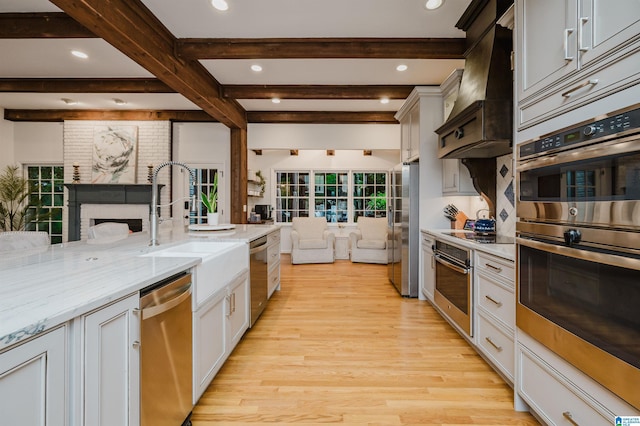 3204 Woodford Way, Birmingham, AL 35242 - kitchen with stainless steel appliances, custom exhaust hood, light wood-style floors, open floor plan, and beam ceiling