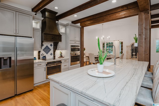 3204 Woodford Way, Birmingham, AL 35242 - kitchen featuring appliances with stainless steel finishes, beam ceiling, premium range hood, tasteful backsplash, and light wood-style flooring