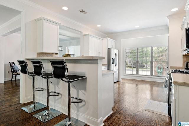 5912 Waterscape Pass, Hoover, AL 35244 - kitchen featuring stainless steel appliances, dark wood finished floors, a breakfast bar area, light countertops, and crown molding