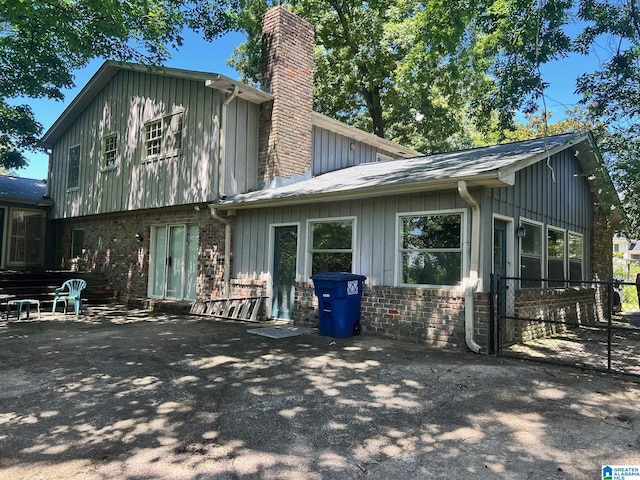 2341 Regent Ln, Hoover, AL 35226 - back of house featuring board and batten siding, a chimney, and a patio