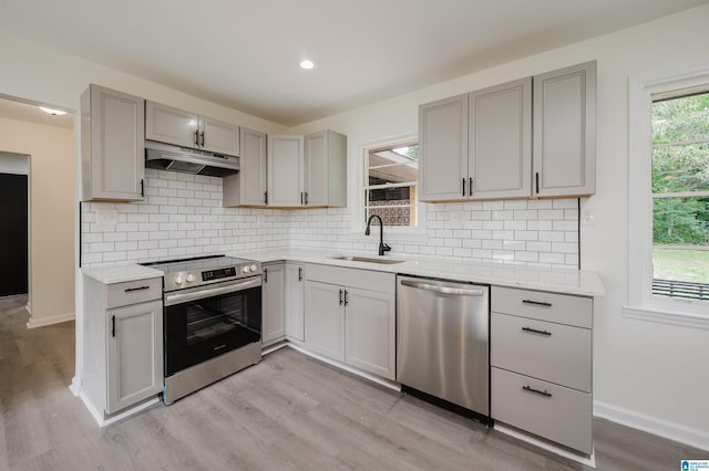 201 Sun Valley Rd, Center Point, AL 35215 - kitchen featuring stainless steel appliances, under cabinet range hood, gray cabinets, light wood-style floors, and decorative backsplash