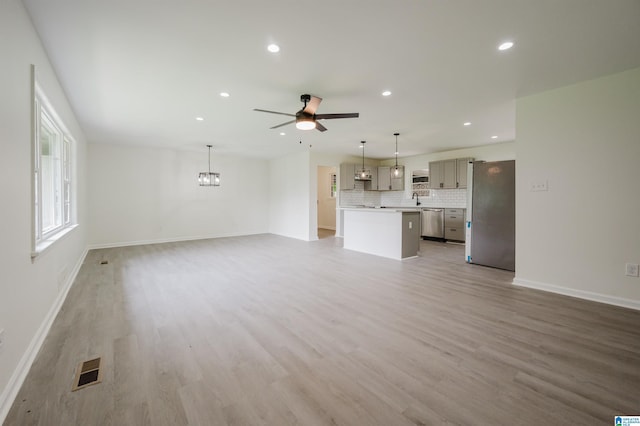 201 Sun Valley Rd, Center Point, AL 35215 - unfurnished living room with ceiling fan, recessed lighting, light wood-style flooring, and a chandelier