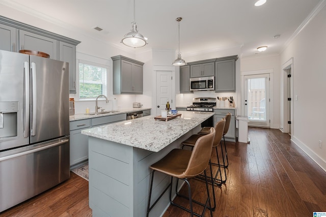 1268 Shades Ter, Irondale, AL 35210 - kitchen with appliances with stainless steel finishes, gray cabinets, crown molding, light stone counters, and a breakfast bar area
