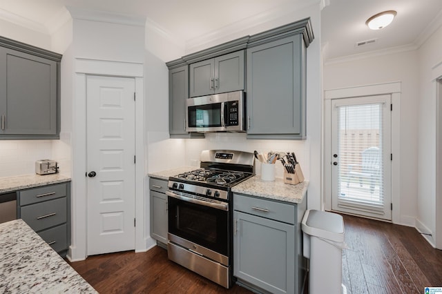 1268 Shades Ter, Irondale, AL 35210 - kitchen featuring appliances with stainless steel finishes, crown molding, gray cabinetry, dark wood finished floors, and tasteful backsplash