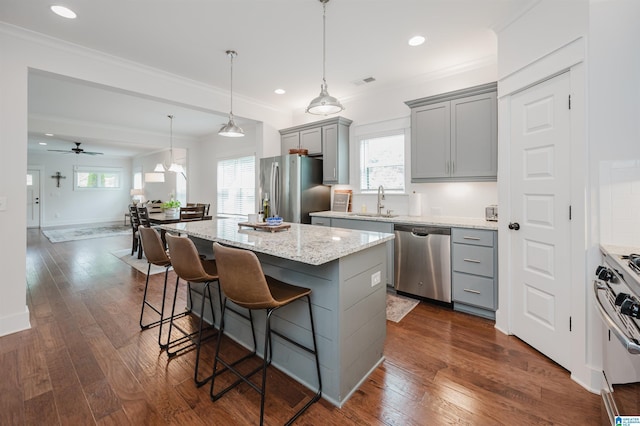 1268 Shades Ter, Irondale, AL 35210 - kitchen with stainless steel appliances, gray cabinets, crown molding, a kitchen island, and a breakfast bar area