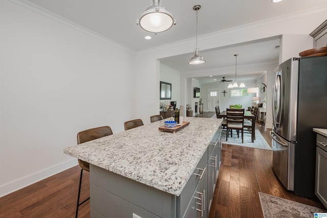 1268 Shades Ter, Irondale, AL 35210 - kitchen featuring freestanding refrigerator, a breakfast bar area, gray cabinets, crown molding, and a center island