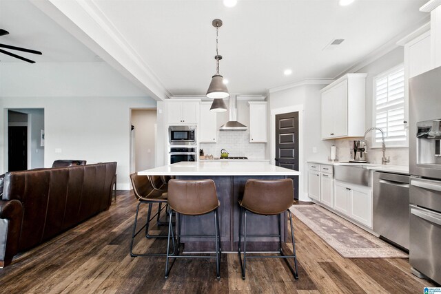 4855 Bo Run, Trussville, AL 35173 - kitchen featuring stainless steel appliances, tasteful backsplash, white cabinetry, a center island, and ornamental molding