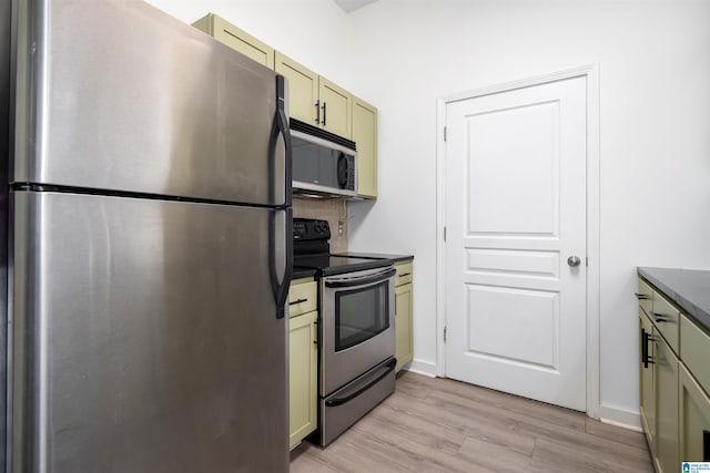 401 20th St S Unit 126, Birmingham, AL 35233 - kitchen with stainless steel appliances, dark countertops, light wood-style flooring, backsplash, and cream cabinetry