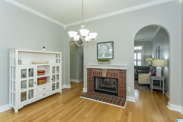 4650 Nicholas Dr, Bessemer, AL 35022 - living area with arched walkways, ornamental molding, light wood-style flooring, a brick fireplace, and a chandelier