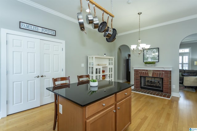 4650 Nicholas Dr, Bessemer, AL 35022 - kitchen featuring arched walkways, crown molding, light wood finished floors, dark countertops, and a kitchen bar