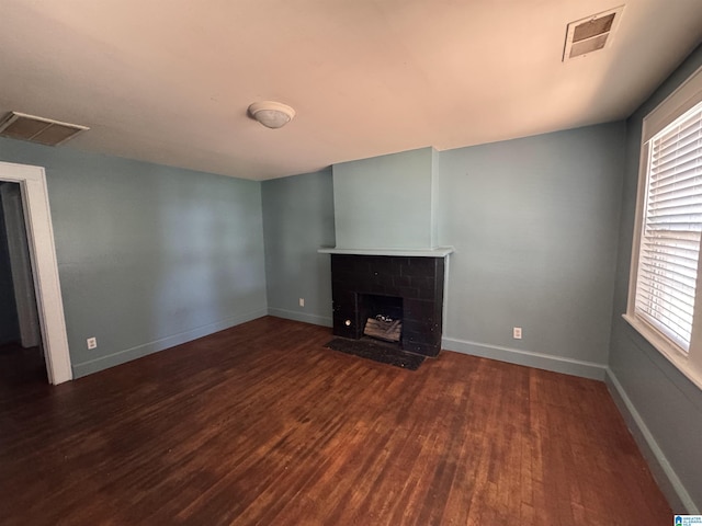 319 Lapsley Ave, Anniston, AL 36207 - unfurnished living room with wood finished floors and a fireplace with flush hearth