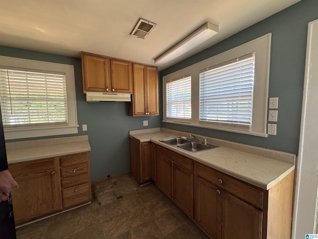 319 Lapsley Ave, Anniston, AL 36207 - kitchen with under cabinet range hood, brown cabinets, and light countertops