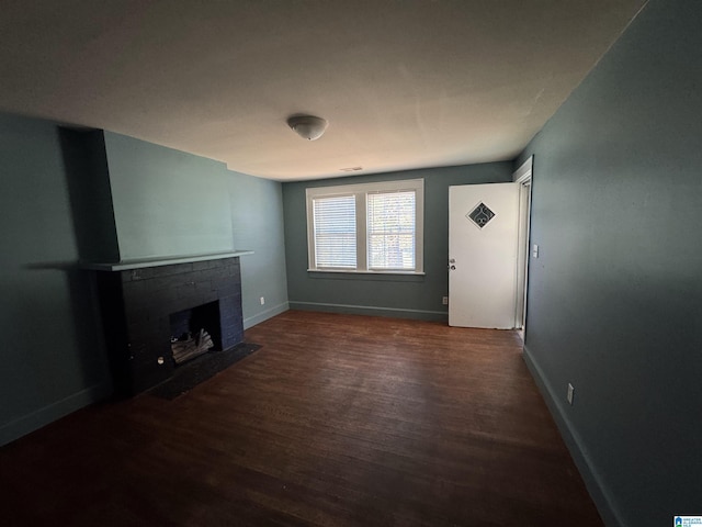 319 Lapsley Ave, Anniston, AL 36207 - unfurnished living room featuring dark wood finished floors and a brick fireplace