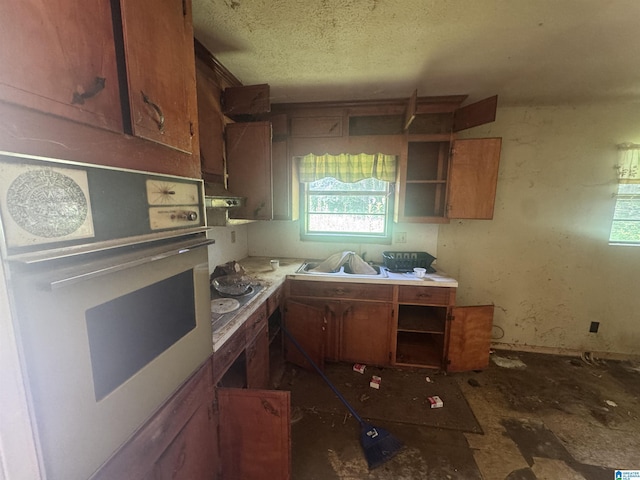 1412 S 7th St, Lanett, AL 36863 - kitchen with white oven, open shelves, plenty of natural light, brown cabinets, and a textured ceiling