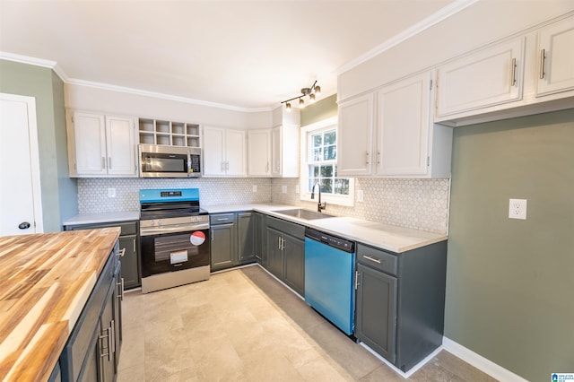1025 Old Mill Rd, Anniston, AL 36207 - kitchen featuring wooden counters, stainless steel appliances, white cabinets, decorative backsplash, and ornamental molding