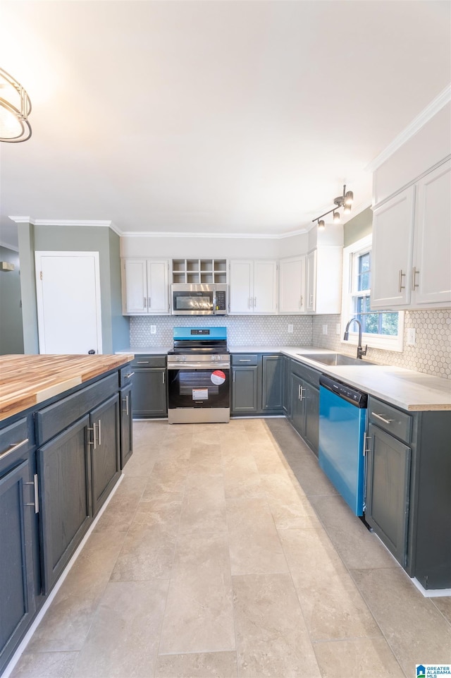 1025 Old Mill Rd, Anniston, AL 36207 - kitchen featuring appliances with stainless steel finishes, white cabinets, tasteful backsplash, and crown molding