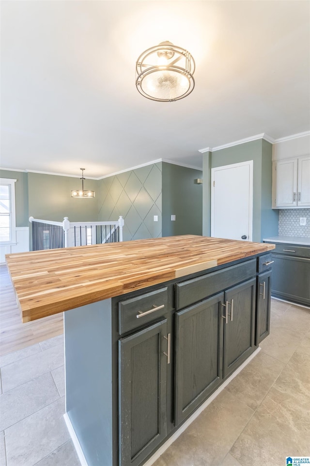 1025 Old Mill Rd, Anniston, AL 36207 - kitchen with wood counters, ornamental molding, a chandelier, backsplash, and a kitchen island