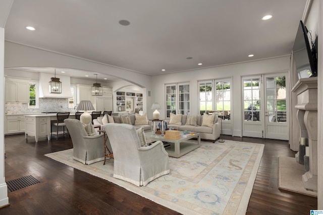 3600 Park Ln S, Mountain Brook, AL 35213 - living room featuring arched walkways, plenty of natural light, dark wood finished floors, recessed lighting, and crown molding