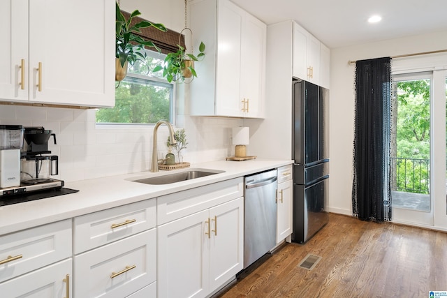 4737 Bankhead Ct, Irondale, AL 35210 - kitchen featuring freestanding refrigerator, stainless steel dishwasher, wood finished floors, white cabinets, and decorative backsplash