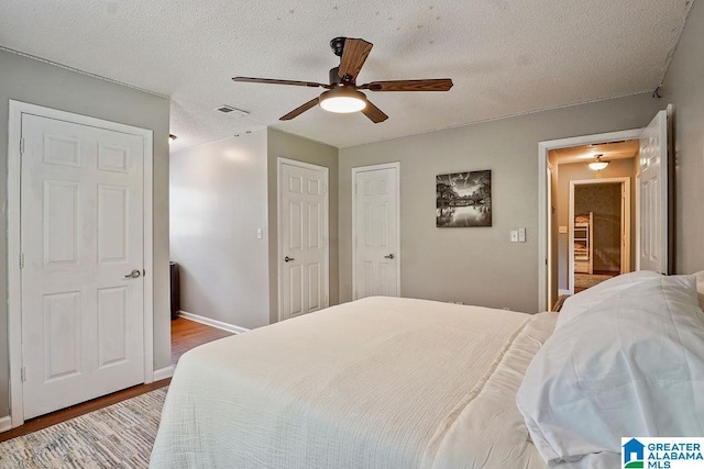 2089 Edenwood Cir, Hueytown, AL 35023 - bedroom featuring wood finished floors, a ceiling fan, and a textured ceiling