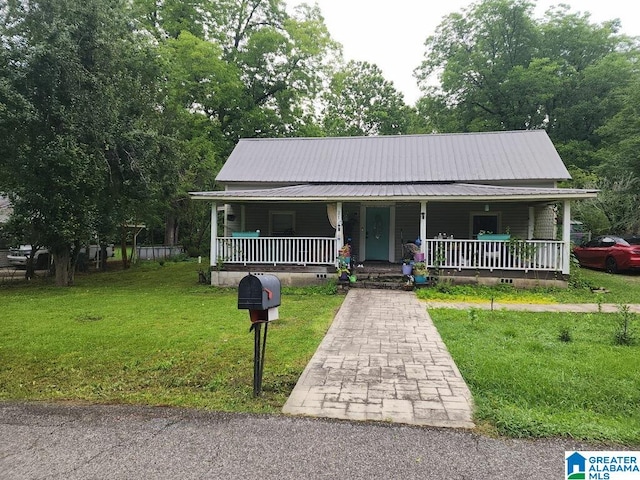 211 3rd St N, Pell City, AL 35125 - view of front of home featuring covered porch, a front lawn, and a metal roof