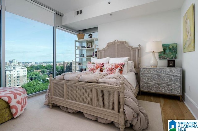 1300 27th Pl Unit 65, Birmingham, AL 35205 - bedroom with multiple windows, wood finished floors, a view of city, and a wall of windows