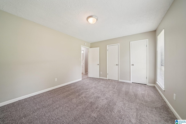 5919 Creekwood Rd, Irondale, AL 35210 - unfurnished bedroom featuring a textured ceiling, carpet, and multiple windows