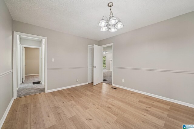 5919 Creekwood Rd, Irondale, AL 35210 - unfurnished dining area featuring a chandelier, light wood-style flooring, and a textured ceiling