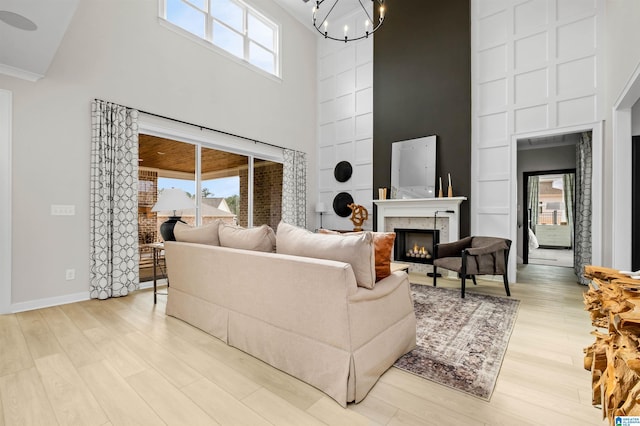 0222 Blackridge Cir, Hoover, AL 35244 - living area featuring a high ceiling, light wood-style flooring, a lit fireplace, and plenty of natural light