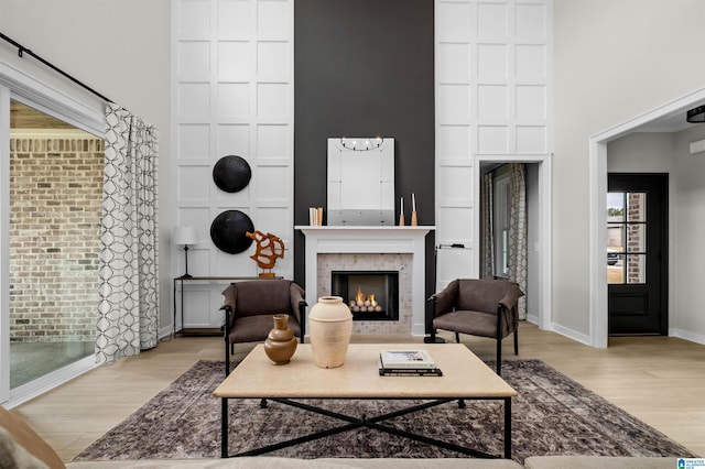 0222 Blackridge Cir, Hoover, AL 35244 - living room with a lit fireplace, light wood-style floors, and a towering ceiling