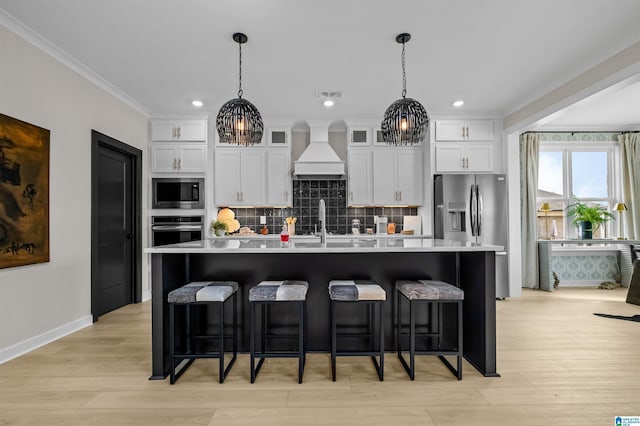 0222 Blackridge Cir, Hoover, AL 35244 - kitchen with stainless steel appliances, premium range hood, a large island with sink, a breakfast bar area, and ornamental molding