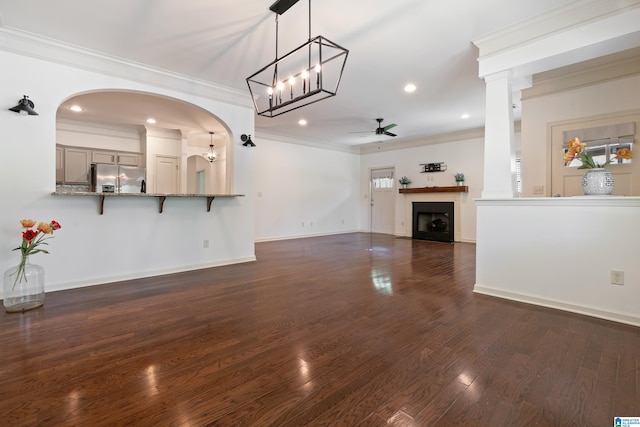 45183 Portobello Rd Unit 183, Birmingham, AL 35242 - unfurnished living room featuring a ceiling fan, dark wood finished floors, a fireplace, crown molding, and arched walkways