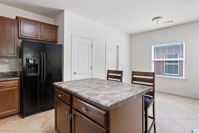394 Glen Cross Way, Trussville, AL 35173 - kitchen with black fridge, backsplash, light tile patterned floors, and a breakfast bar area