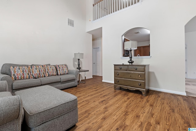 394 Glen Cross Way, Trussville, AL 35173 - living area featuring arched walkways, a towering ceiling, and wood finished floors