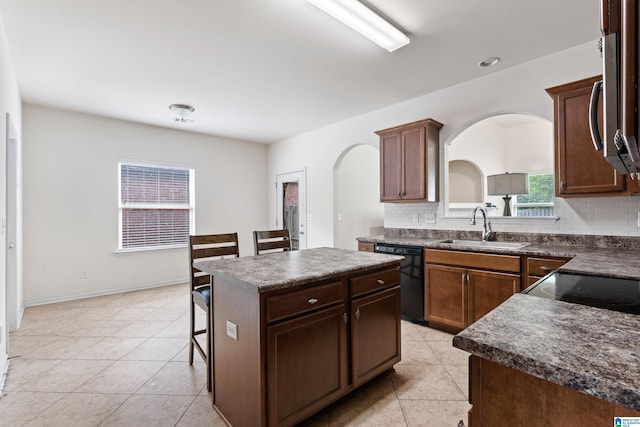 394 Glen Cross Way, Trussville, AL 35173 - kitchen featuring black dishwasher, dark countertops, a kitchen island, arched walkways, and decorative backsplash