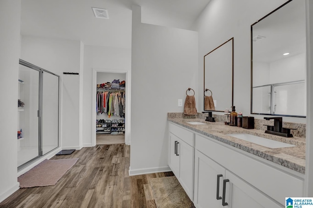 181 Halifax Ln, Chelsea, AL 35043 - full bathroom featuring double vanity, a stall shower, wood finished floors, and a spacious closet