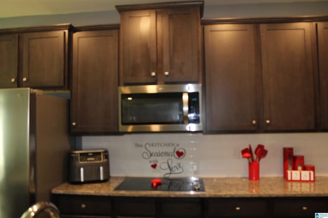 6284 Fieldbrook Cir, Mccalla, AL 35111 - kitchen featuring stainless steel appliances, decorative backsplash, dark brown cabinets, and light stone counters