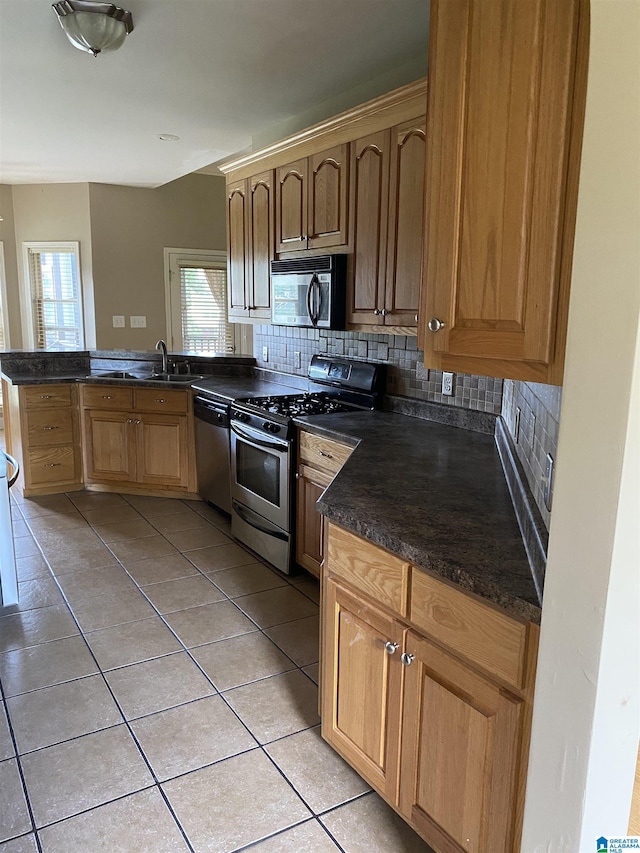 22917 Country Ridge Parkway, Mccalla, AL 35111 - kitchen featuring stainless steel appliances, dark countertops, light tile patterned flooring, and healthy amount of natural light