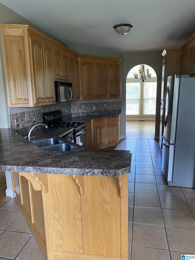 22917 Country Ridge Parkway, Mccalla, AL 35111 - kitchen with freestanding refrigerator, black range with gas cooktop, a chandelier, tasteful backsplash, and a peninsula