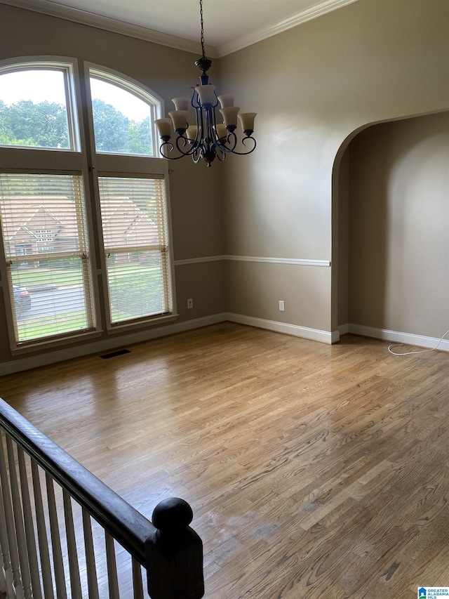 22917 Country Ridge Parkway, Mccalla, AL 35111 - spare room featuring crown molding, light wood-type flooring, a chandelier, and arched walkways