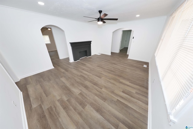 805 Jacksonville St, Weaver, AL 36277 - unfurnished living room featuring ceiling fan, arched walkways, wood finished floors, a fireplace, and recessed lighting