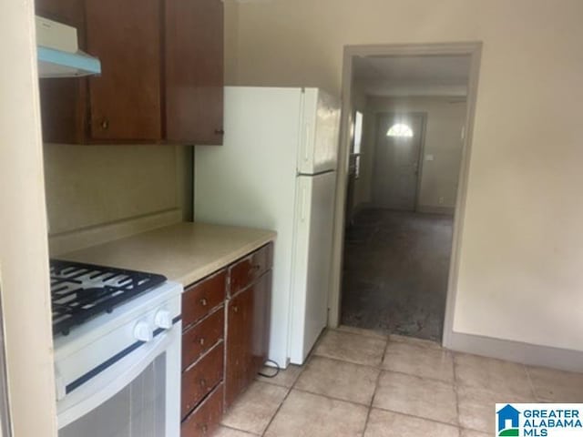 605 39th Pl, Fairfield, AL 35064 - kitchen with white appliances, light countertops, light tile patterned floors, and wall chimney exhaust hood