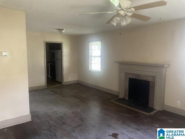 605 39th Pl, Fairfield, AL 35064 - unfurnished living room featuring a fireplace with raised hearth, ceiling fan, and a textured ceiling